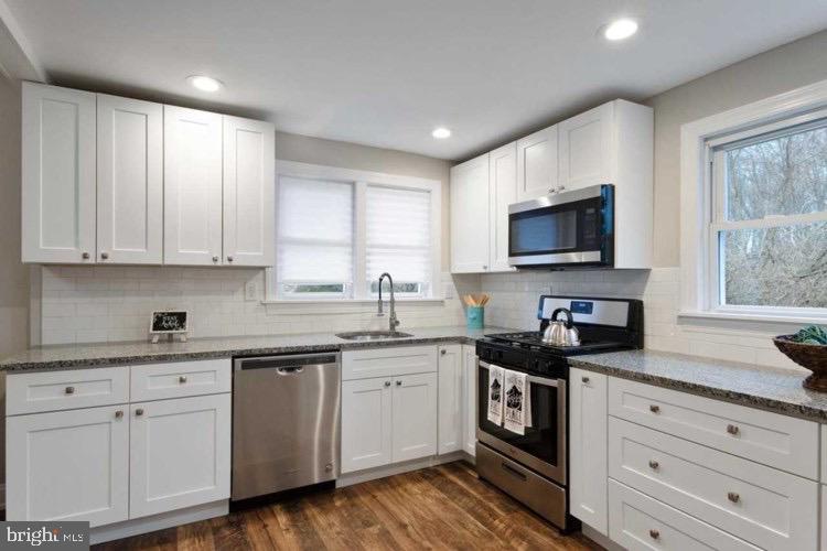 14 Sewell Street Glassboro, NJ 08028 - Photo 9 of 15 a kitchen with a sink stove cabinets and wooden floor