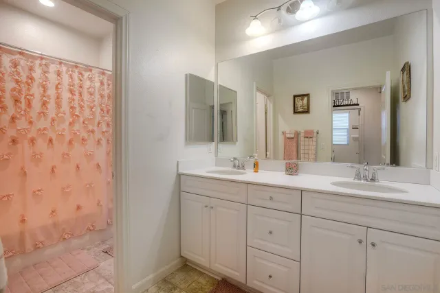 a bathroom with a double vanity sink and mirror