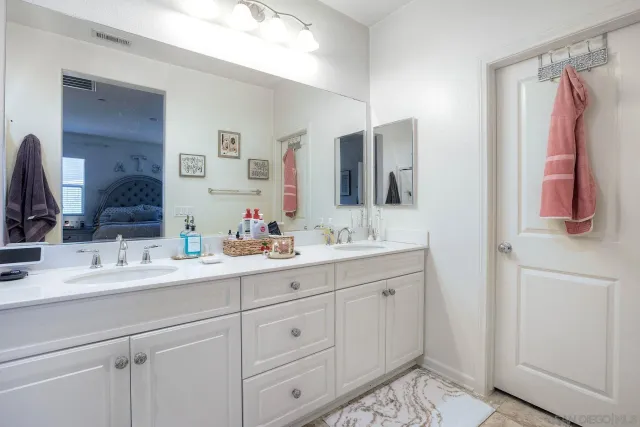 a bathroom with a double vanity sink and mirror
