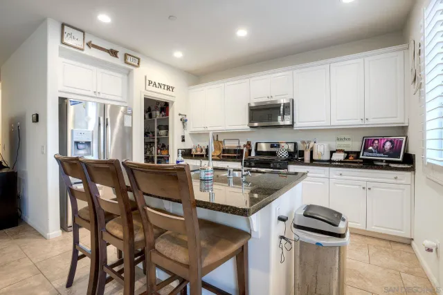 a kitchen with a dining table chairs and white cabinets