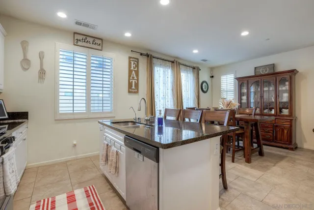 a kitchen with kitchen island granite countertop a sink stove and cabinets