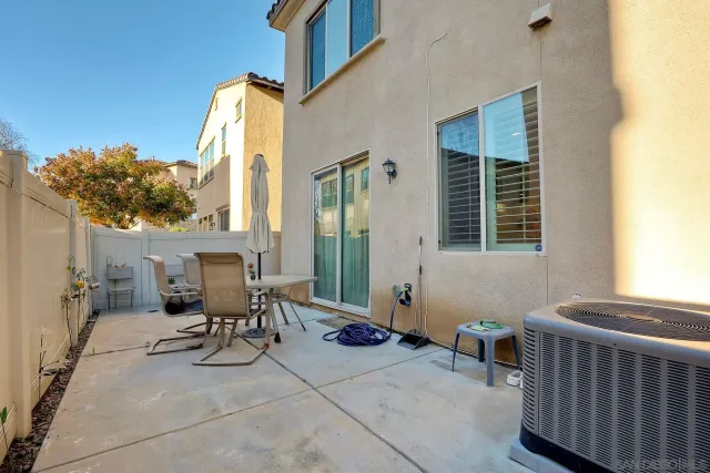 a view of patio with a table and chairs and iron fence