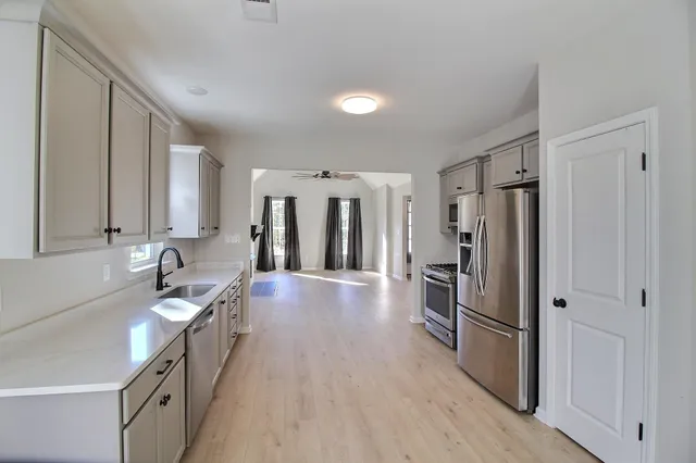 a view of an empty room with window and hardwood floor