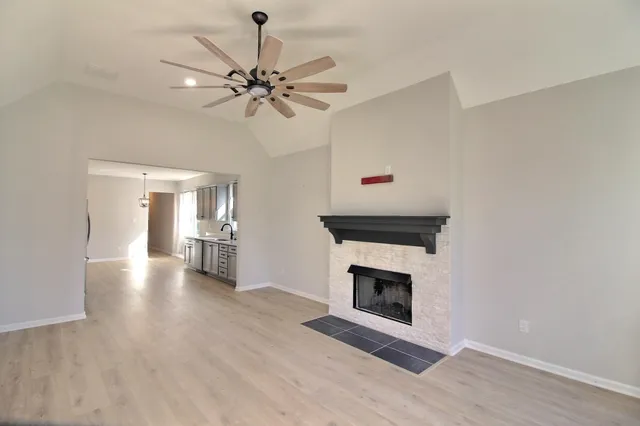 a view of a livingroom with a fireplace and a ceiling fan