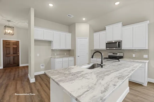 a kitchen with granite countertop a stove and a sink