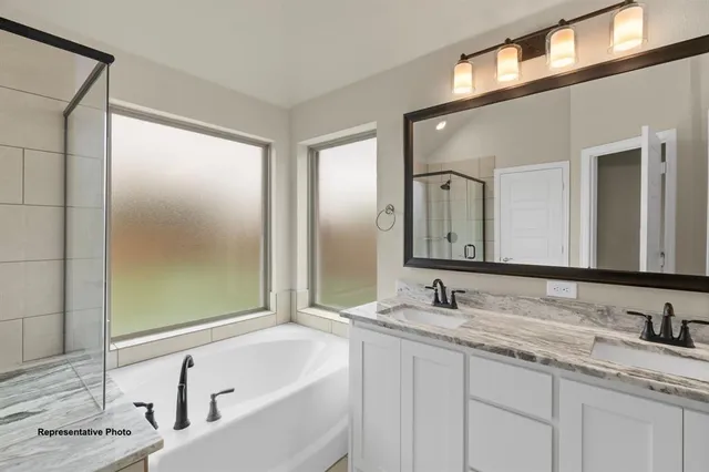a bathroom with a granite countertop sink mirror and a bathtub