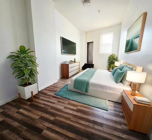 a living room with furniture potted plant and a flat screen tv