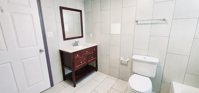 a bathroom with a toilet sink vanity and mirror