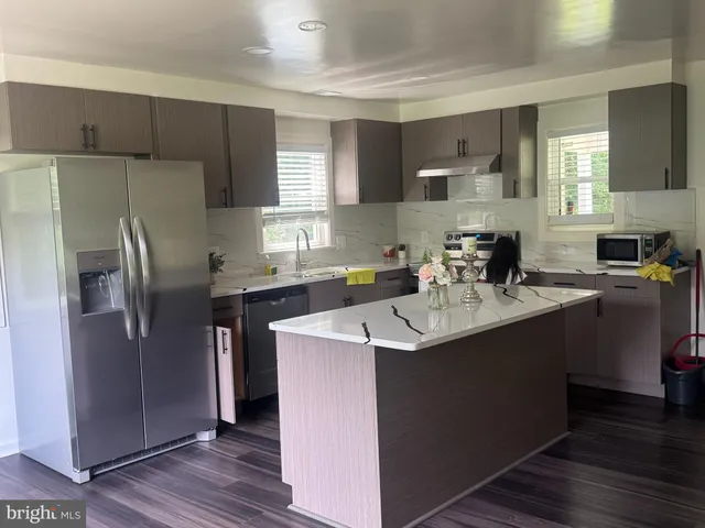 a kitchen with kitchen island a sink appliances and cabinets
