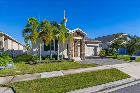 a front view of a house with a yard and potted plants