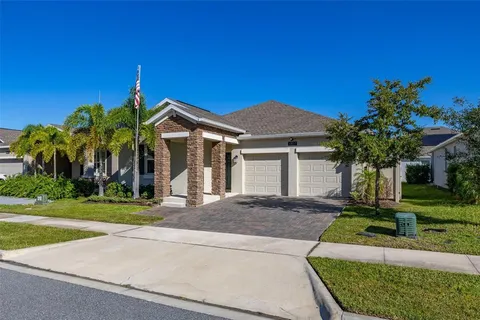 a front view of a house with a yard and potted plants