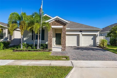 a view of a house with a yard and large tree