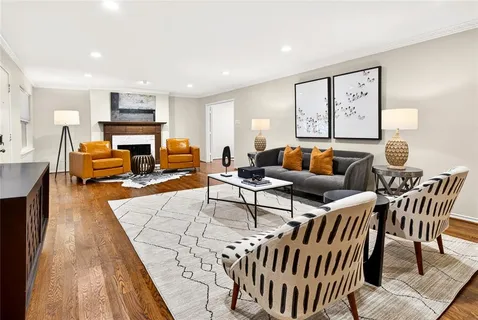 a living room with furniture wooden floor and a large window