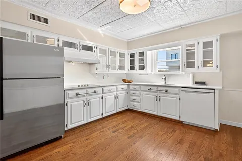 a kitchen with stainless steel appliances a sink cabinets and wooden floor