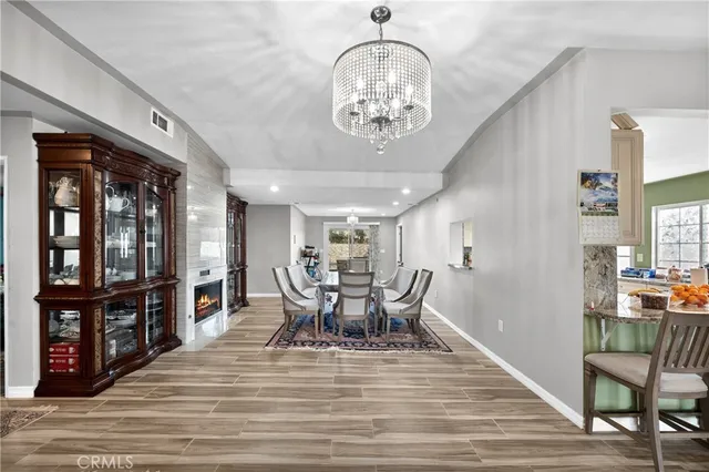 a view of a dining room with furniture a chandelier and wooden floor