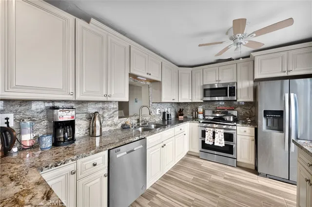 a kitchen with kitchen island granite countertop a sink stainless steel appliances and cabinets