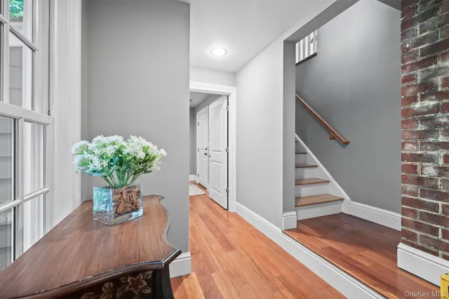 a view of a hallway with wooden floor and glass top table