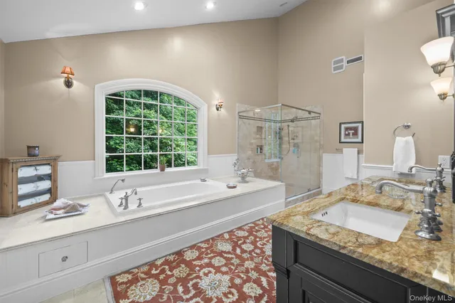 a bathroom with a granite countertop sink and a large mirror