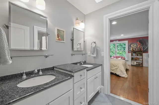 a en suite bathroom with a granite countertop sink and a mirror