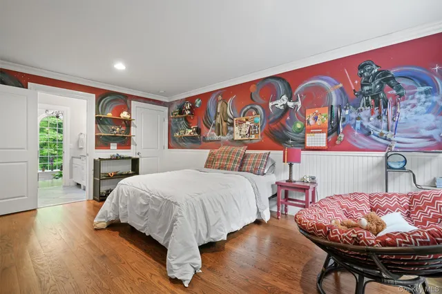 a bedroom with a bed and dresser with wooden floor