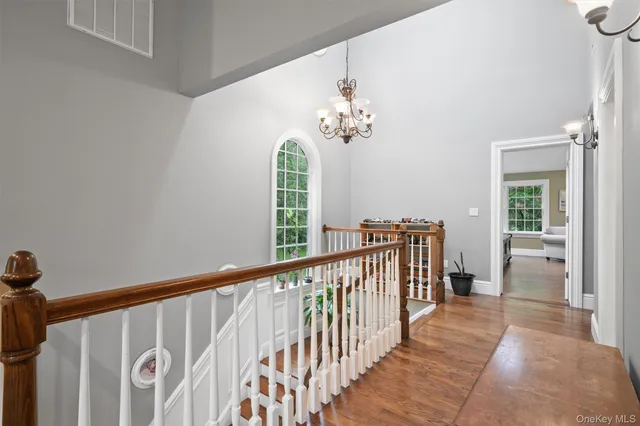 a view of a hallway with wooden floor and windows