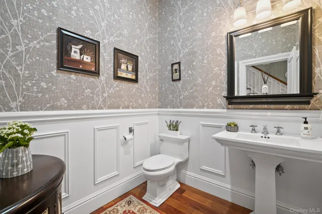 a bathroom with a toilet a sink and mirror