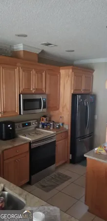 a room with a table chairs and appliances