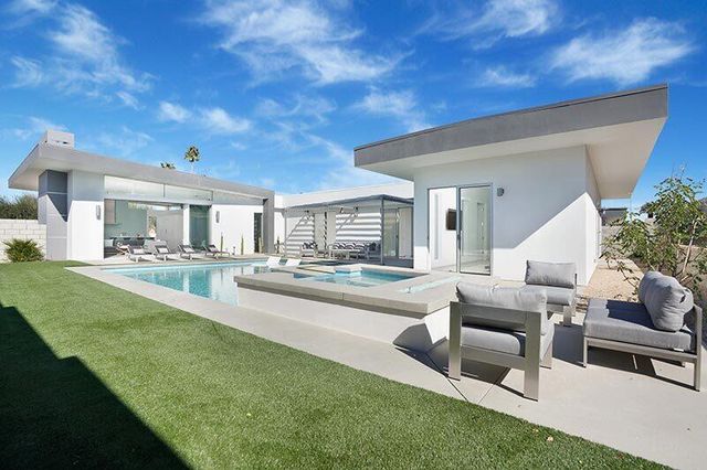 a view of a house with swimming pool and sitting area