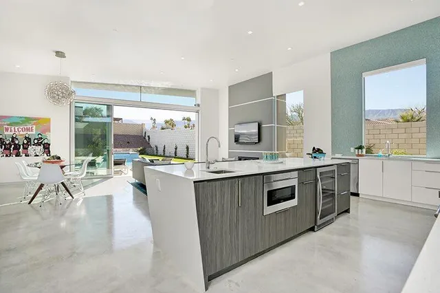 a large kitchen with kitchen island a sink a stove and a refrigerator