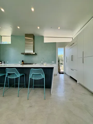 a kitchen with cabinets table and chairs