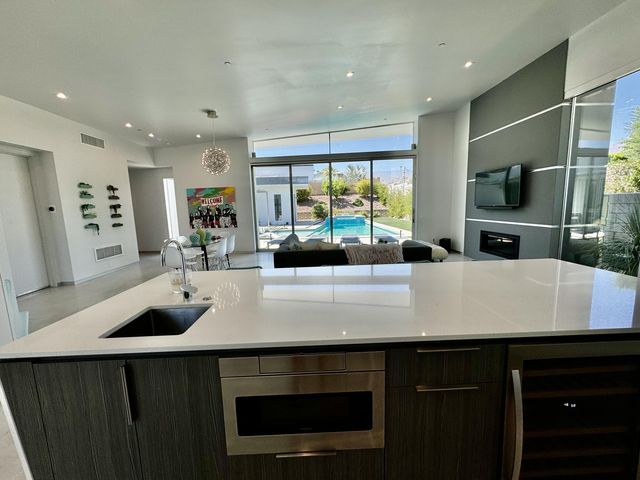 a kitchen with kitchen island a sink appliances and a counter top space