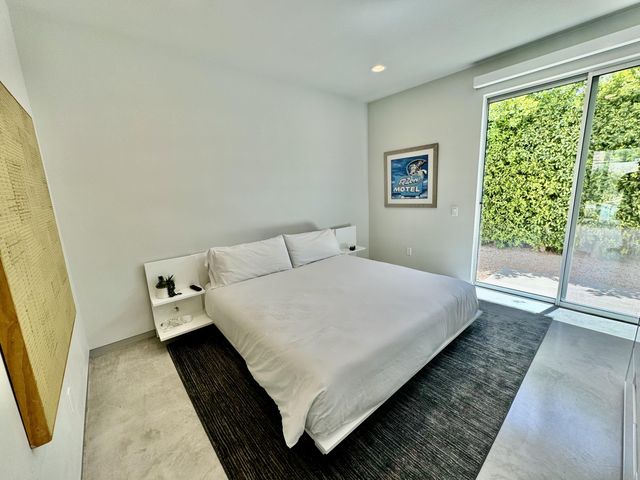 a bed sitting in a bedroom next to a window