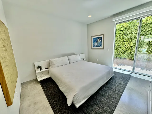 a bed sitting in a bedroom next to a window