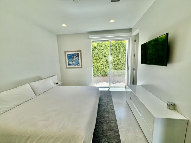 a spacious bedroom with a large bed and a flat screen tv