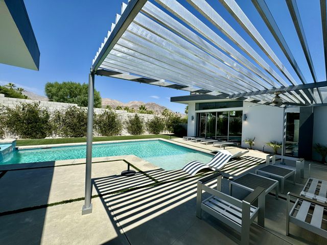 a view of a patio with table and chairs with wooden floor and fence