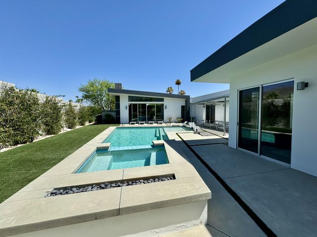 a view of a house with pool and chairs