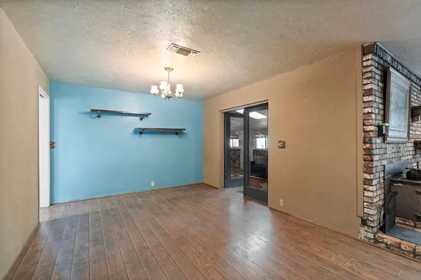 a kitchen with stainless steel appliances granite countertop a refrigerator a sink dishwasher a stove and a dining table with wooden floor