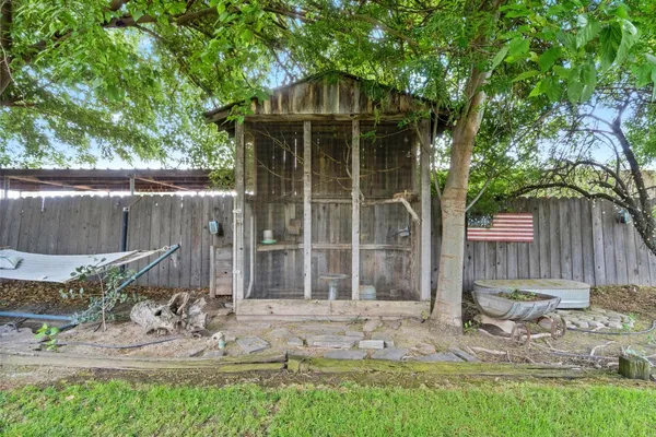 a front view of a house with a garden and trees