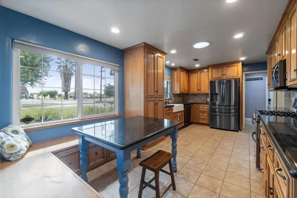 a large kitchen with stainless steel appliances granite countertop a stove a sink dishwasher and a microwave