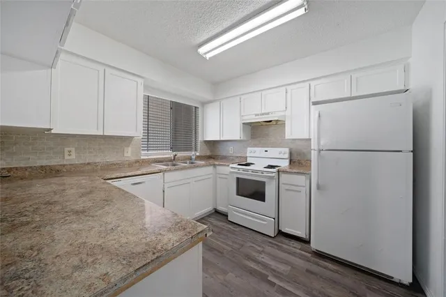 a kitchen with a refrigerator stove and white cabinets