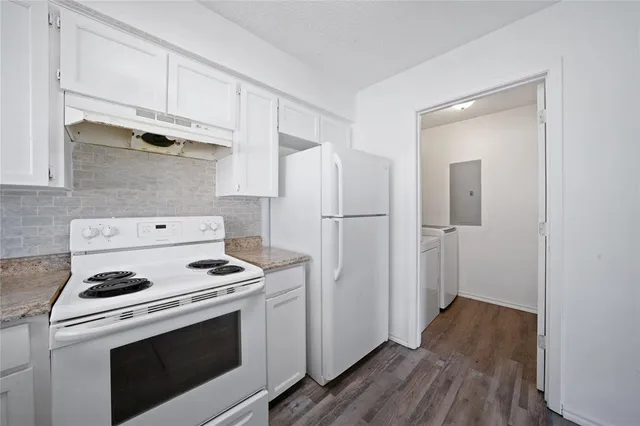 a kitchen with white cabinets and white appliances