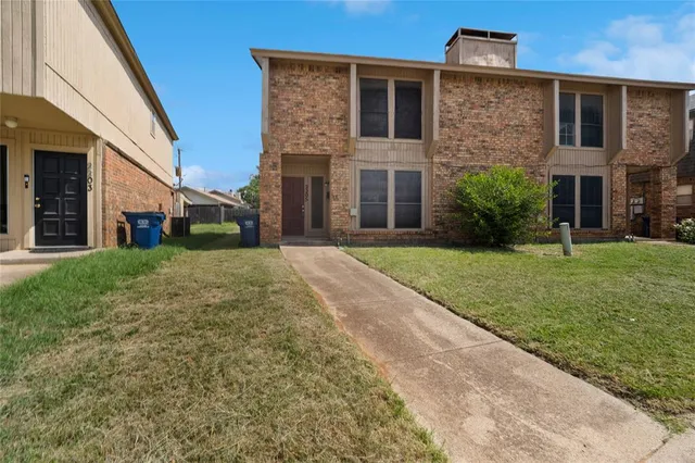 a view of a brick house with a yard
