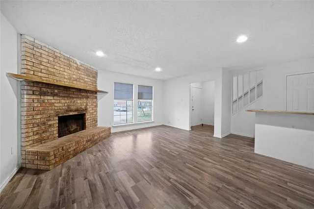a view of a livingroom with wooden floor and a fireplace