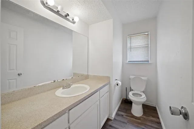 a bathroom with a granite countertop sink a toilet and a mirror