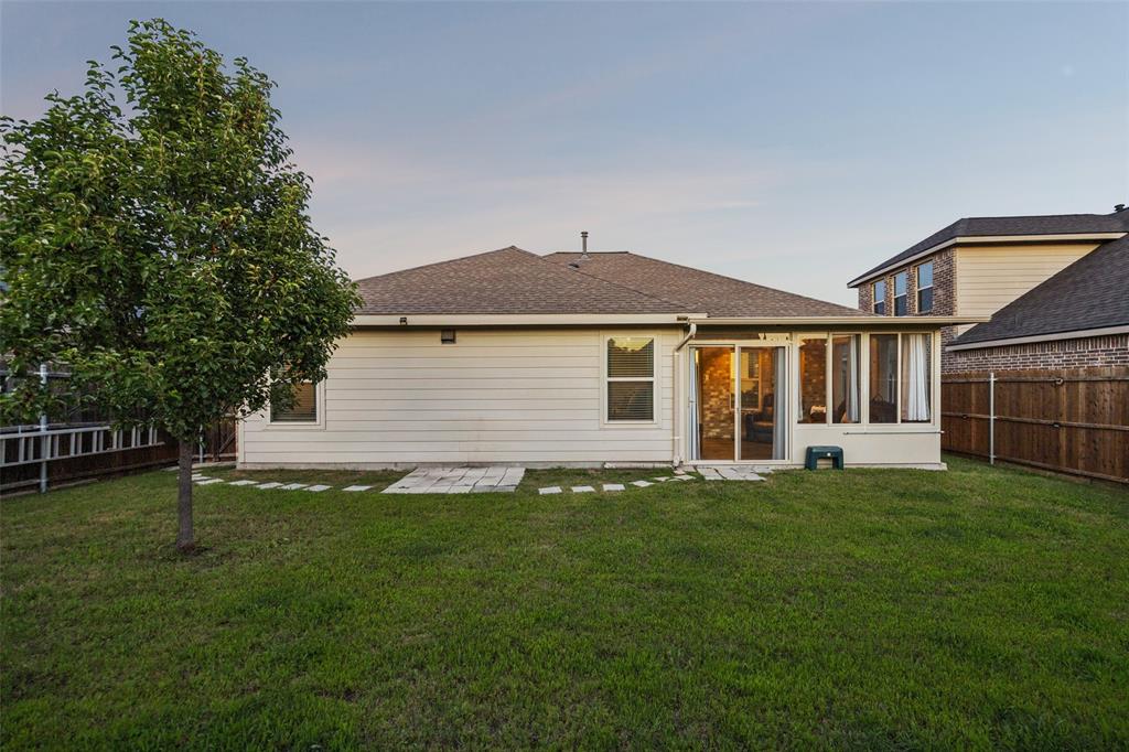 406 Madrone Lane Princeton, TX 75407 - Photo 24 of 30 Expansive backyard featuring a green lawn, mature tree, and privacy fencing
