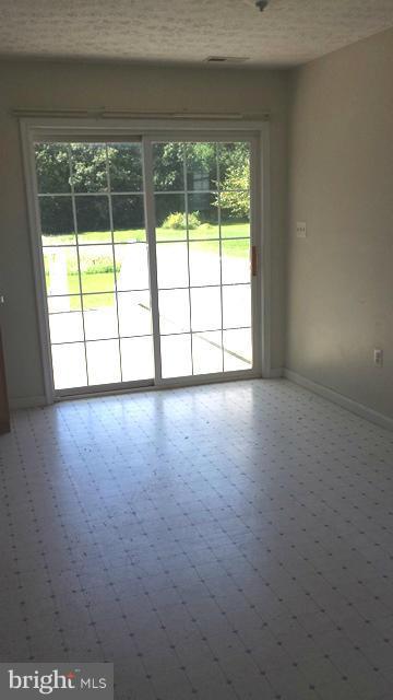 13765 Point Lookout Road Ridge, MD 20680 - Photo 5 of 15 a view of an empty room with wooden floor and a window