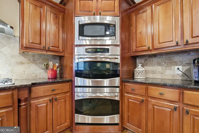 a kitchen with granite countertop cabinets stainless steel appliances and wooden cabinets
