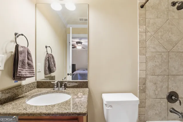 a bathroom with a granite countertop sink and a mirror
