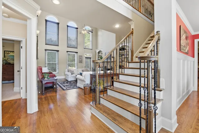 a living room with wooden floor furniture and a potted plant