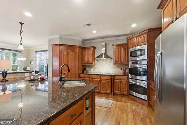 a kitchen with stainless steel appliances granite countertop a sink refrigerator and cabinets